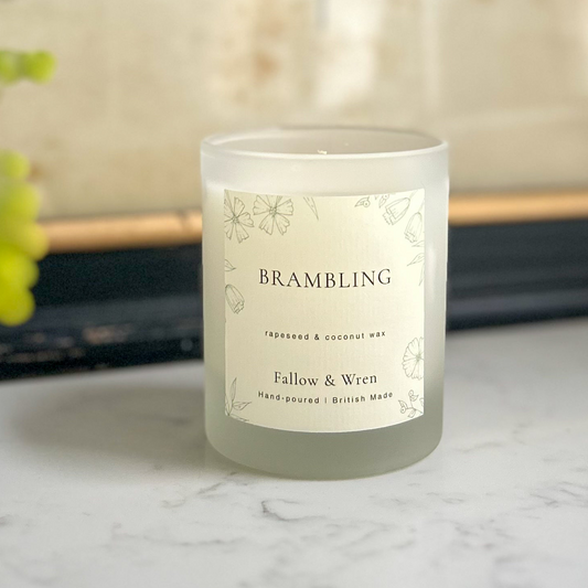 Candle with a 'Brambling' label on a marble surface